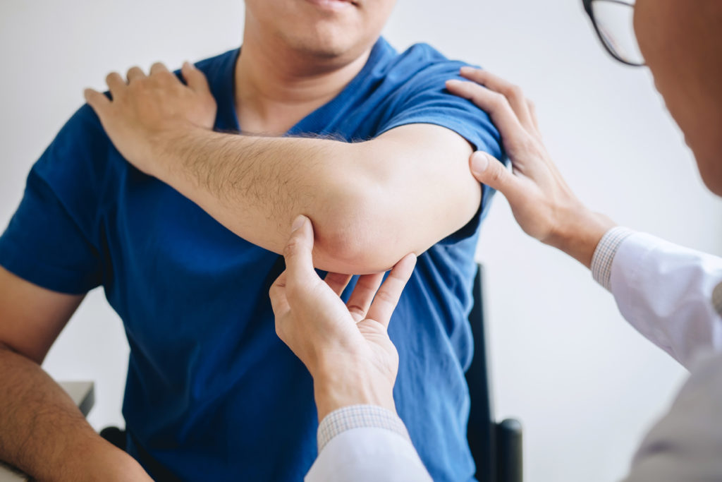 Physiotherapist helping patient with an elbow injury